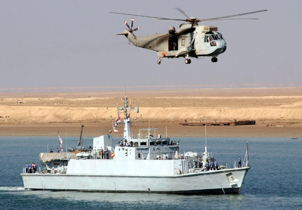 A Royal Australian Navy Sea King passes over HMS Sandown on patrol