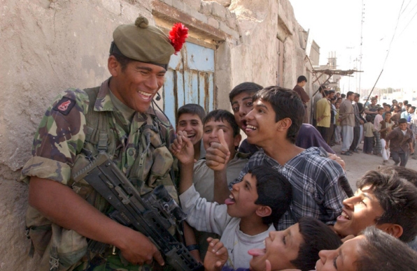 A Fijian member of 1st Battalion The Black Watch with some of the children of Al Zubayr