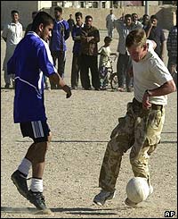 British Troops play football with locals