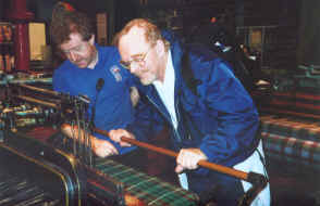I check my work on the pedal powered loom where I turn out a scrap of tartan under the supervision of a master weaver.